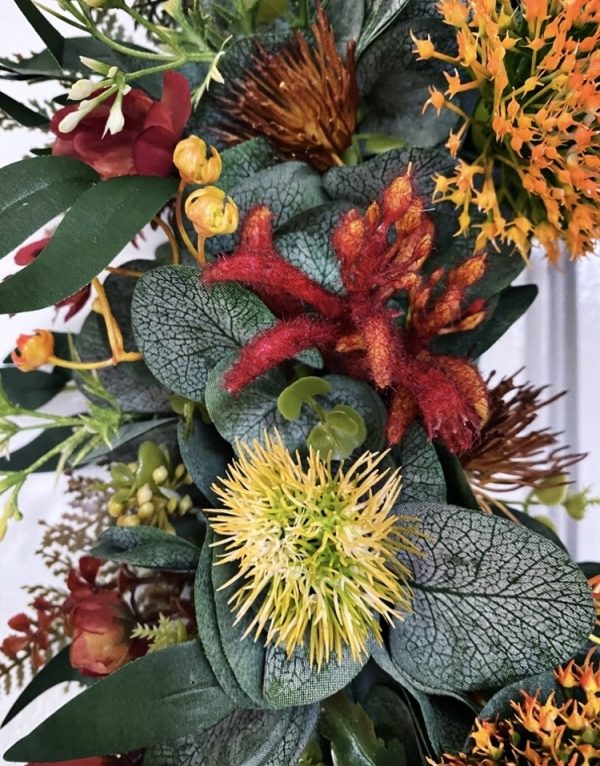 close up of native christmas wreath showing yellow native fkower, red kangaroo paw, orange pincushion and green eucalyptus leaves